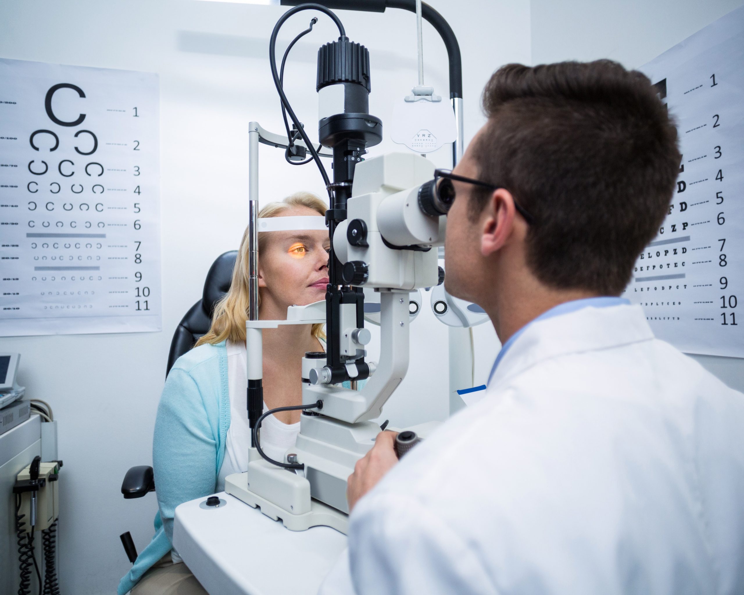 optometrist examining female patient on slit lamp